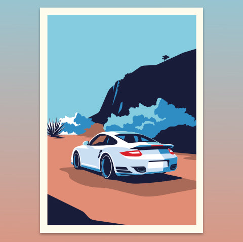 White sports car on a desert road with mountains in the background